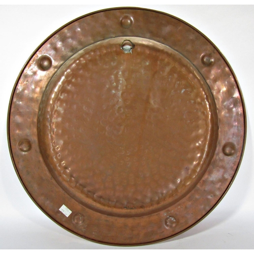 1683 - A late 19th century copper charger with a hammered finish 54.5cm diam.