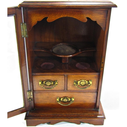 1705 - A Victorian oak smokers cabinet with a full glazed door revealing three drawers and three mixing pla... 