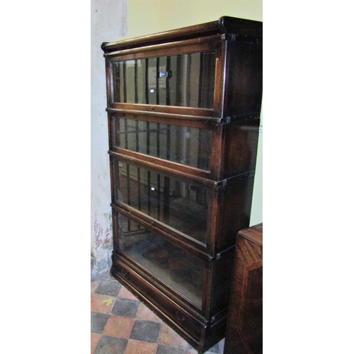 2676 - A four tier Globe Wernicke oak framed sectional bookcase with glazed up and over doors and one singl... 