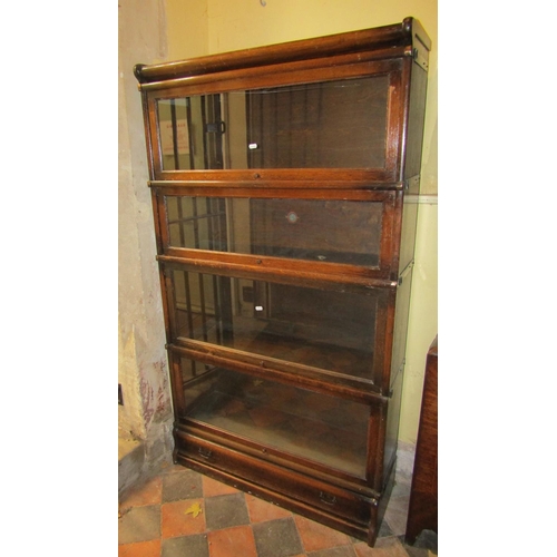 2676 - A four tier Globe Wernicke oak framed sectional bookcase with glazed up and over doors and one singl... 