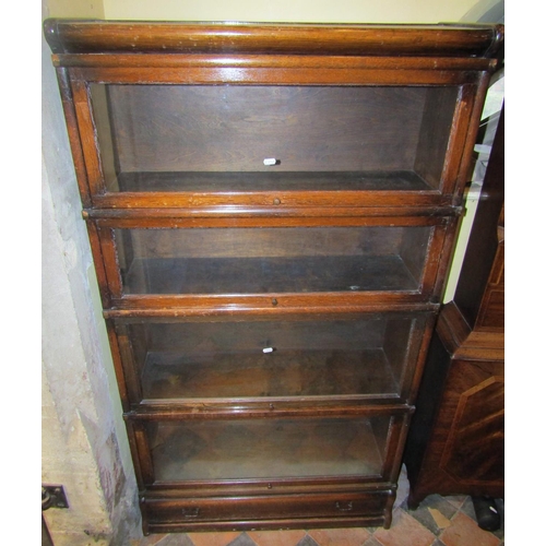 2676 - A four tier Globe Wernicke oak framed sectional bookcase with glazed up and over doors and one singl... 