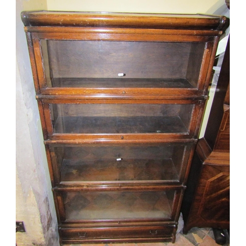 2676 - A four tier Globe Wernicke oak framed sectional bookcase with glazed up and over doors and one singl... 