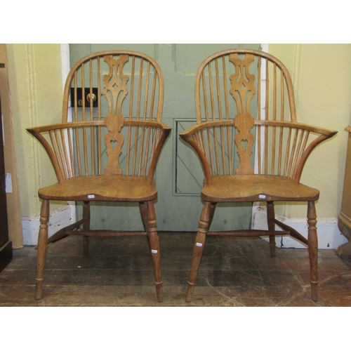 2704 - A pair of 19th century Windsor hoop back elbow chairs with shaped and pierced splats with dished elm... 