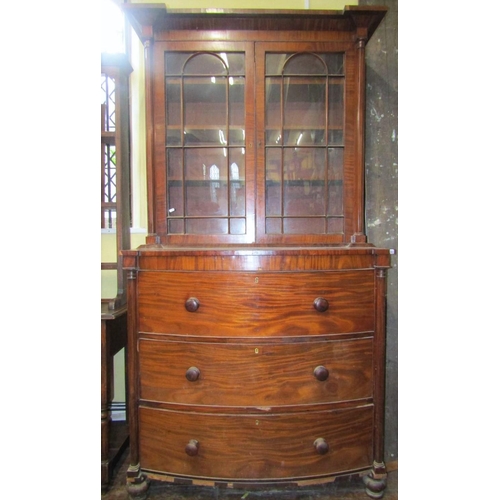 2743 - A regency mahogany secretaire bookcase, the base of bow fronted outline fitted with two deep drawers... 