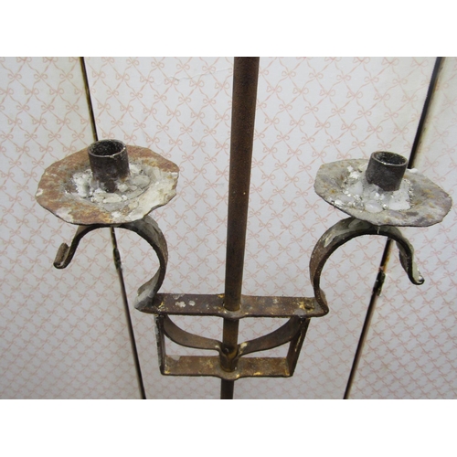 2750 - A wrought iron candle stand to support two candles, with adjustable height raised on three pad feet