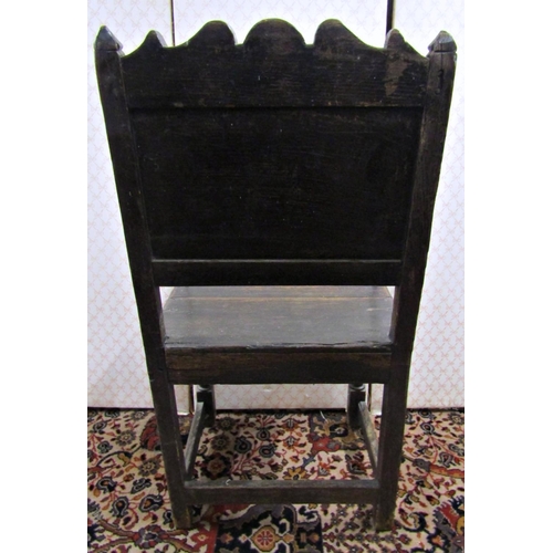 2762 - An 18th century oak side chair with solid seat and panelled back incorporating a stylised floral des... 