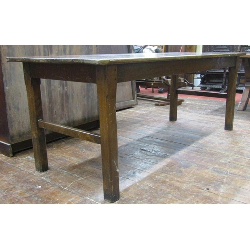 2778 - A Georgian oak farmhouse kitchen table, the plank top raised on chaffered supports, united by end ra... 