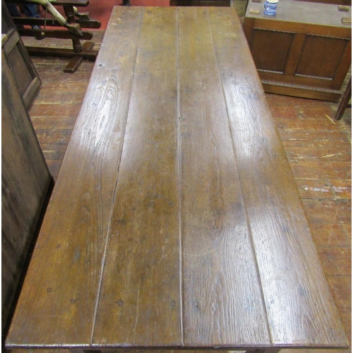 2778 - A Georgian oak farmhouse kitchen table, the plank top raised on chaffered supports, united by end ra... 