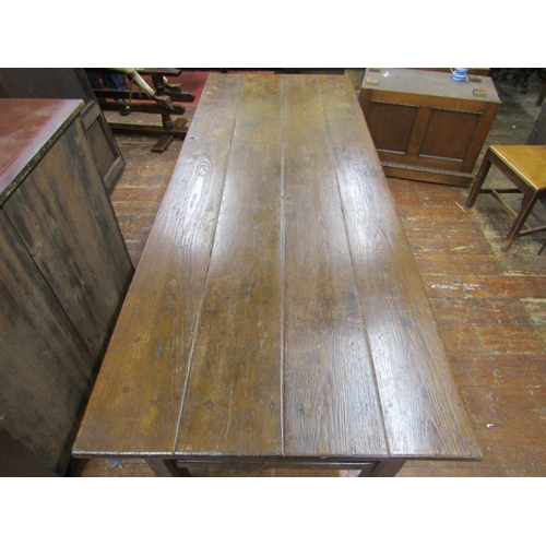 2778 - A Georgian oak farmhouse kitchen table, the plank top raised on chaffered supports, united by end ra... 