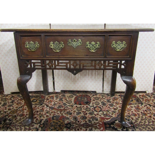 2807 - Georgian oak lowboy raised on shaped forelegs enclosing three drawers with shaped frieze