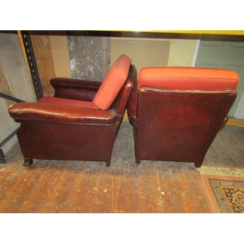 2701 - A pair of late Edwardian club chairs, the framework upholstered in maroon leather with later upholst... 