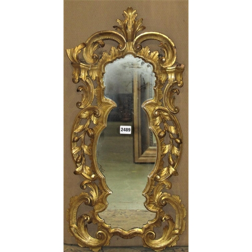 2489 - A small 19th century wall mirror with shaped outline and scrolling acanthus frame, 72 cm x 35 cm (af... 