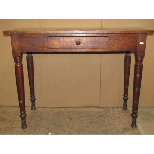 2502 - An Edwardian oak side table with central frieze drawer raised on ring turned and tapered supports, 9... 