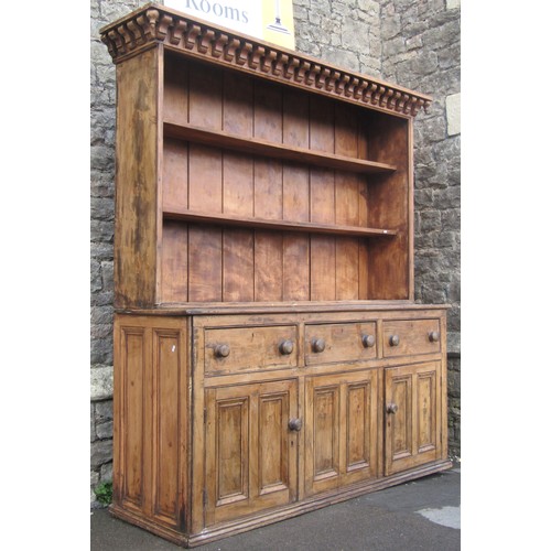 2409 - A 19th century stripped pine farmhouse kitchen dresser, the base partially enclosed by a pair of mou... 