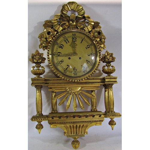 1513 - A gilded wall clock the decorative casework with column, floral and ribbon detail enclosing an eight... 