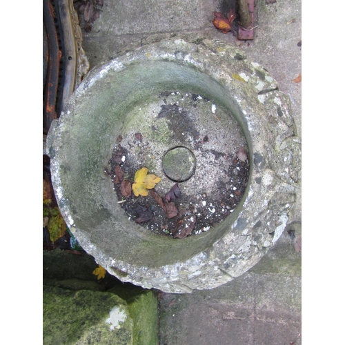 2007 - A weathered cast composition stone garden urn of circular form, raised on squat pedestal with stylis... 