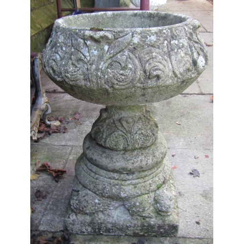 2007 - A weathered cast composition stone garden urn of circular form, raised on squat pedestal with stylis... 