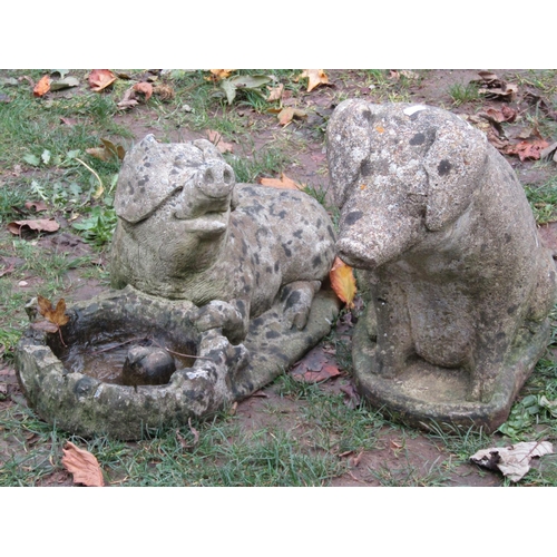 2026 - Two weathered cast composition stone novelty garden ornaments in the form of pigs, seated example 42... 