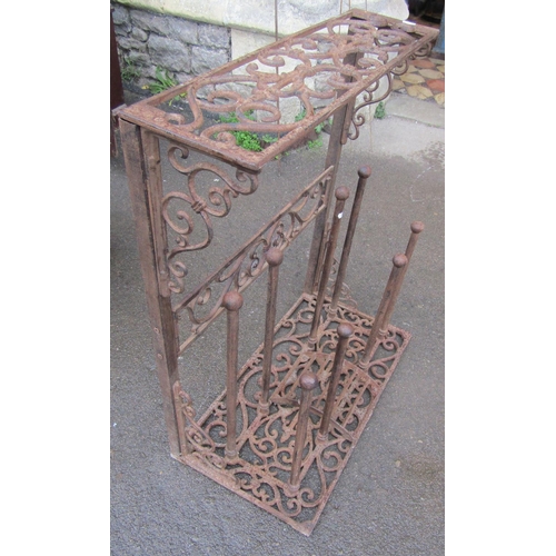 2032 - A weathered contemporary cast iron boot stand with decorative pierced scrollwork detail, 64 cm wide ... 