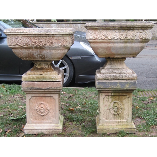 2037 - A pair of weathered cast composition stone square tapered garden urns, raised on loose socles and as... 