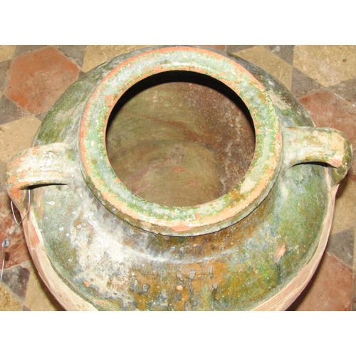 2080 - An old terracotta jar with green glazed neck moulded loop handles and combed detail, 60 cm high