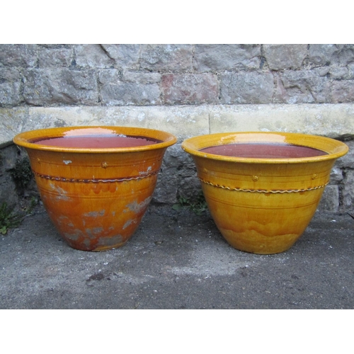 2089 - A pair of vintage ochre glazed planters of circular tapered form with flared rims, press moulded ban... 