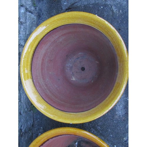 2089 - A pair of vintage ochre glazed planters of circular tapered form with flared rims, press moulded ban... 