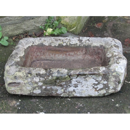 2107 - A shallow but thick walled weathered natural stone trough of rectangular form, 58 cm long x 30 cm wi... 