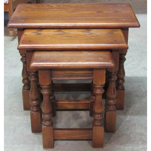 2220 - A nest of three graduated oak occasional tables in the old English style raised on turned and block ... 