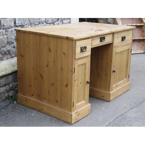 2231 - A pine kneehole twin pedestal desk fitted with three frieze drawers over cupboards enclosed by panel... 