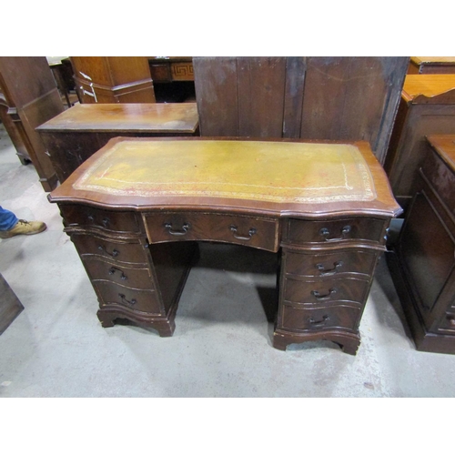 2300 - A reproduction mahogany veneered kneehole twin pedestal writing desk with serpentine outline and a f... 