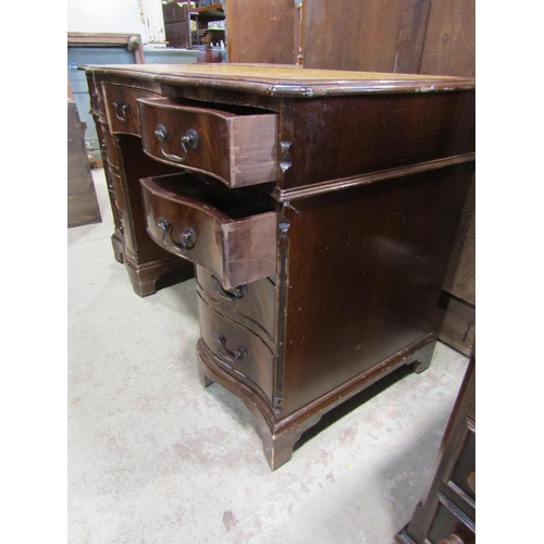 2300 - A reproduction mahogany veneered kneehole twin pedestal writing desk with serpentine outline and a f... 