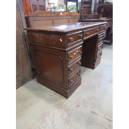 2304 - A reproduction mahogany kneehole twin pedestal writing desk, with inset leather panel top set over a... 