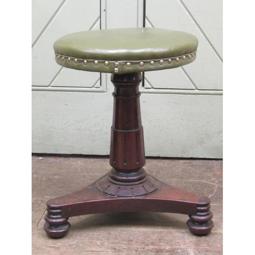 2683 - A William IV mahogany piano stool upholstered in green leather, raised on an adjustable column and t... 