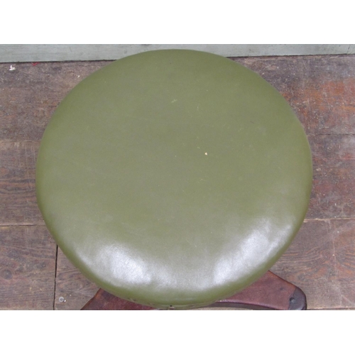 2683 - A William IV mahogany piano stool upholstered in green leather, raised on an adjustable column and t... 