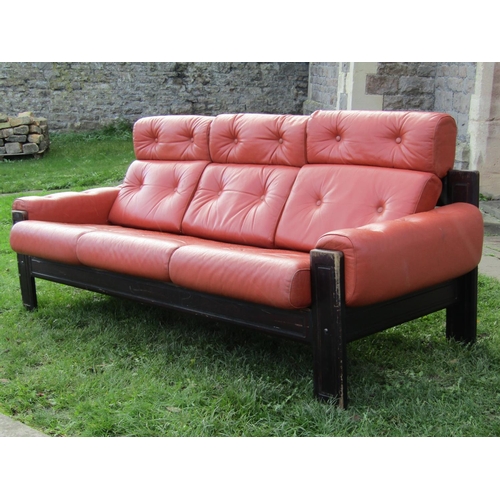 2690 - A contemporary three seat sofa with ebonised frame, upholstered and buttoned in leather, 2m wide