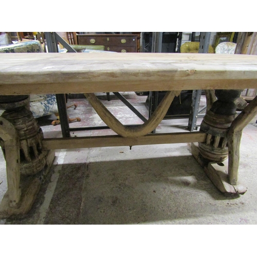 2625 - A rustic farmhouse table, the heavy plank top raised on reclaimed farm wagon hubs and further shaped... 