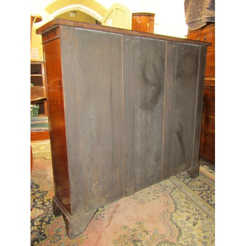 2695 - A mahogany enclosed bookcase in the Georgian style with glazed panelled doors, raised on bracket sup... 