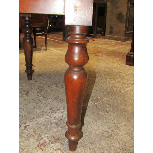 2634 - A 19th century mahogany drop leaf dining table on four turned supports, the top with swivel action t... 