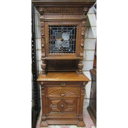 2650 - A 19th century oak pier cabinet, the lower section enclosed by a panelled door with lion mask and ot... 