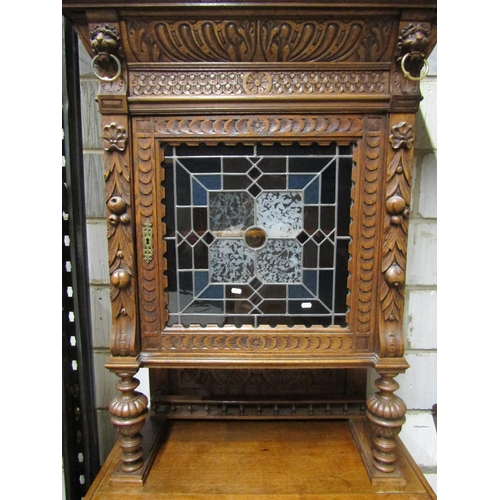 2650 - A 19th century oak pier cabinet, the lower section enclosed by a panelled door with lion mask and ot... 