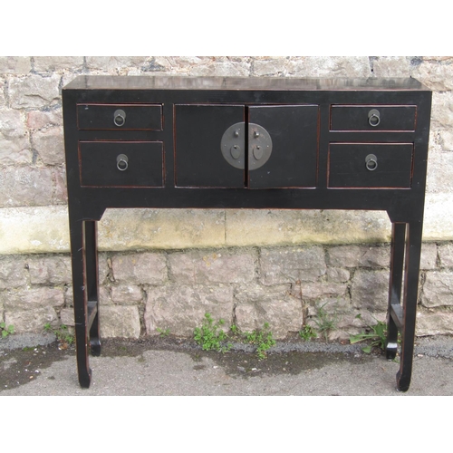 2653 - A Chinese side table with black lacquered finish enclosed by a central cupboard and four drawers on ... 