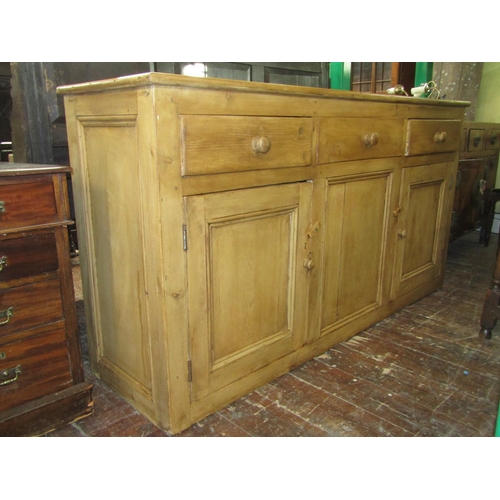 2721 - A 19th century stripped and waxed pine kitchen dresser base enclosed by three panelled doors and thr... 