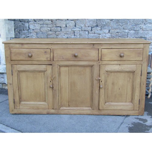 2721 - A 19th century stripped and waxed pine kitchen dresser base enclosed by three panelled doors and thr... 