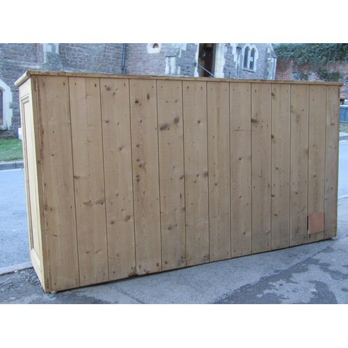 2721 - A 19th century stripped and waxed pine kitchen dresser base enclosed by three panelled doors and thr... 