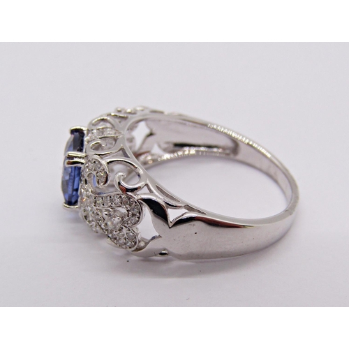 1413 - 18k white gold cushion-cut tanzanite and diamond ring with scrolled openwork setting, size N, 3.9g