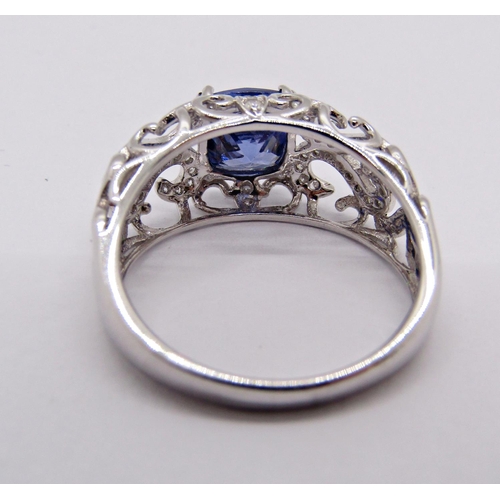 1413 - 18k white gold cushion-cut tanzanite and diamond ring with scrolled openwork setting, size N, 3.9g