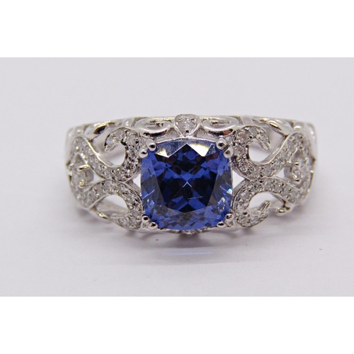 1413 - 18k white gold cushion-cut tanzanite and diamond ring with scrolled openwork setting, size N, 3.9g