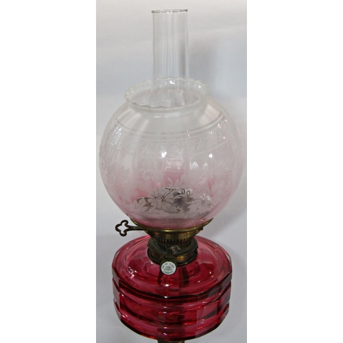 1747 - A J & S Lee & Sons Hinks patent oil lamp with a cranberry glass reservoir supported by a brass colum... 