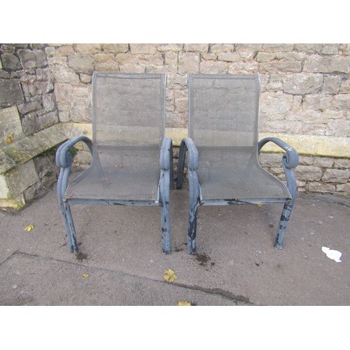 2010 - A green painted tubular steel framed two seat rocking garden bench with interlaced strapwork seat an... 